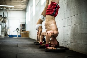man and woman doing handstand pushups